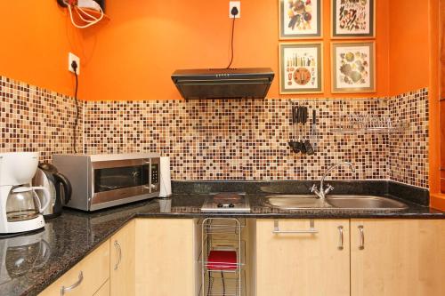 a kitchen with a sink and a microwave at Kleinbosch Lodge in Stellenbosch