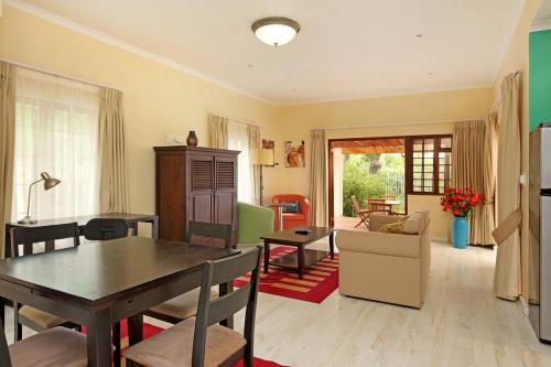 a kitchen and living room with a table and chairs at Kleinbosch Lodge in Stellenbosch