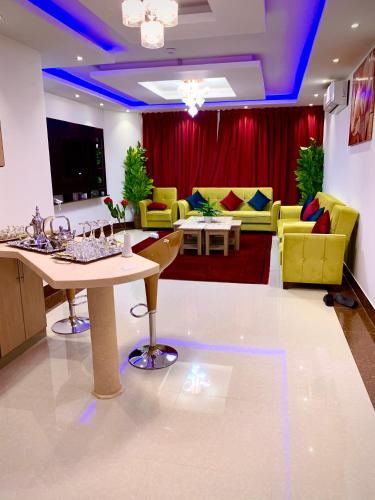 a living room with a table and yellow chairs at شقق حدائق الزيتون للوحدات السكنية -اقتصادية in Hail