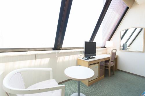 an office with a desk with a computer and a chair at Tabist Hotel Tetora Kitakyushu in Kitakyushu