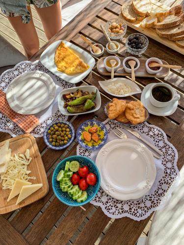 einen Tisch mit Teller und Schalen mit Lebensmitteln in der Unterkunft Kemerlihan Deluxe Hotel in Alacati