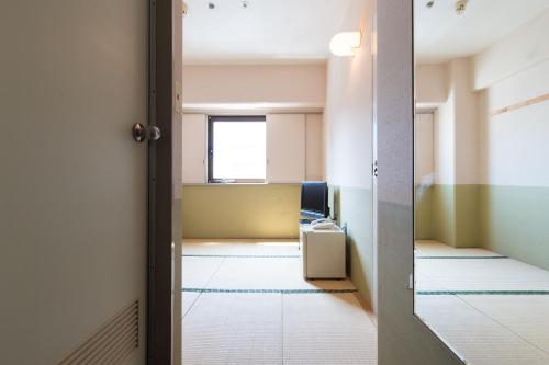 an empty room with a door leading to an office at Tabist Hotel Tetora Kitakyushu in Kitakyushu
