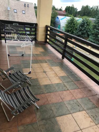 a couple of chairs sitting on a balcony at House on the sea side in Ragaciems