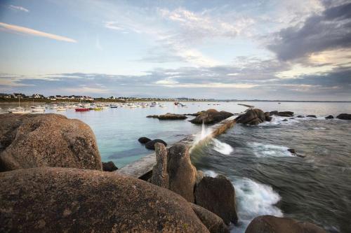 a beach with rocks and boats in the water at Charmante Maison Bretonne à 2 minutes des plages in Plouescat