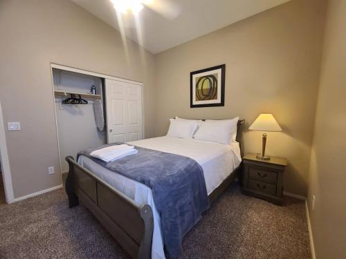 a bedroom with a bed and a nightstand with a lamp at Phoenix II Minutes to Airport and Downtown in Phoenix
