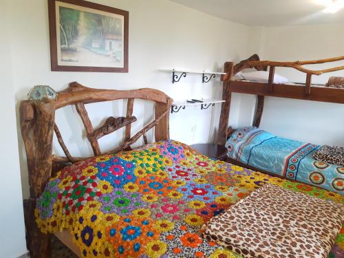 Apartamento Campestre Medellin في ميديلين: غرفة نوم مع سريرين بطابقين مع لحاف ملون