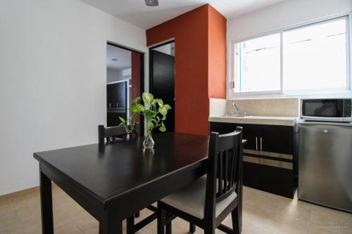 kuchnia z czarnym stołem, krzesłami i zlewem w obiekcie Gayser Apartamentos w mieście Valladolid