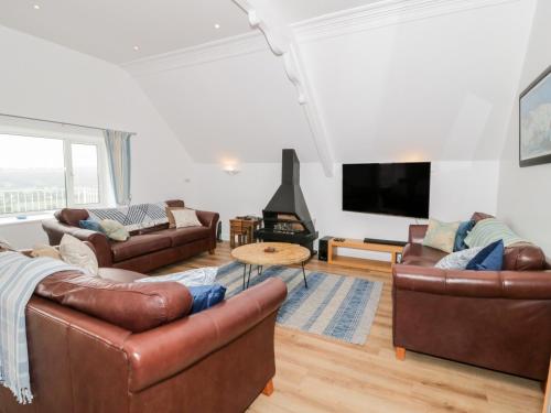 a living room with leather furniture and a flat screen tv at Saron Chapel in Llandudno