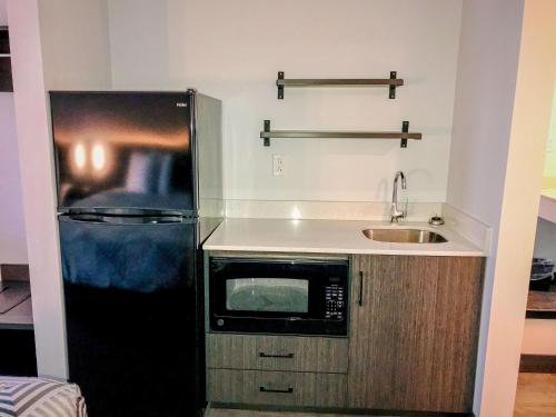 uma cozinha com um frigorífico preto e um lavatório em Studio 6 Dublin, Ga em Dublin