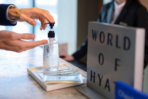 a person is holding a bottle on a table at Hyatt Place Boston/Seaport District in Boston