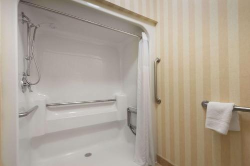 a white bathroom with a shower and a toilet at Baymont by Wyndham Colorado Springs in Colorado Springs