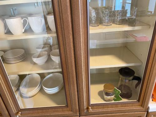 a cabinet filled with plates and cups and dishes at Hotel EL Utsunomiya 7 free parking in Utsunomiya