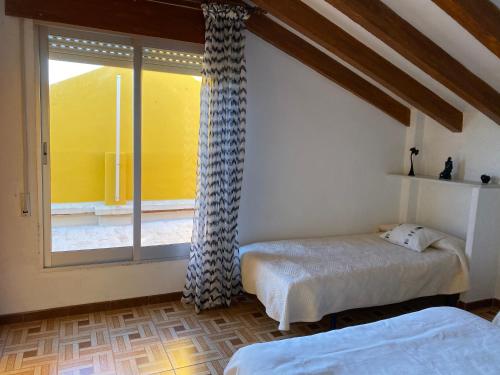 une chambre avec deux lits et une fenêtre dans l'établissement 1era linea de playa VILLA MARGARET Cullera Marenyet, à Cullera