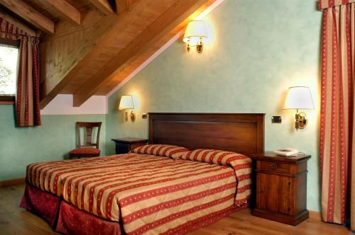 a bedroom with a bed with a wooden head board at Hotel Vittoria in Premeno