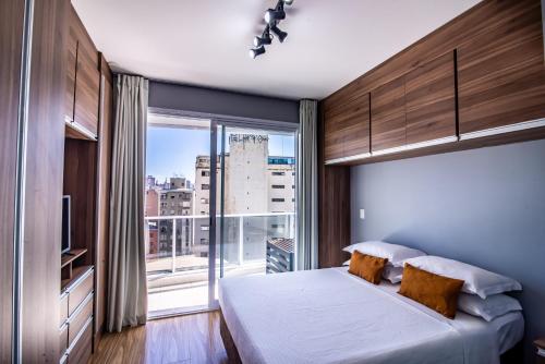 a bedroom with a bed and a large window at 360 Luz in Sao Paulo