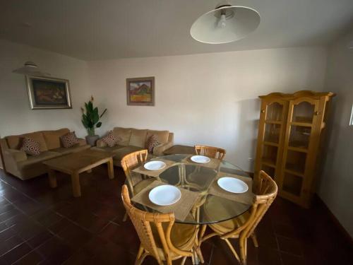 een woonkamer met een glazen tafel en stoelen bij Céntrica Suite Ubicada Av Zaragoza B31 in Casa Blanca La Corregidora