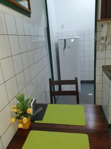 Una habitación con una mesa con un jarrón de flores. en Suíte 1, aconchegante, privativa e independente, en Cuiabá