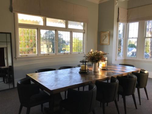 a dining room with a wooden table and chairs at Cedar House in Gisborne