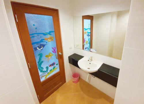 W łazience znajduje się umywalka i lustro. w obiekcie B Space Residence w mieście Nong Prue