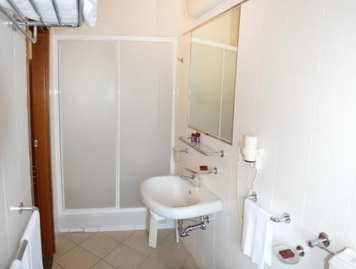 uma casa de banho branca com um lavatório e um chuveiro em Hotel Olimpic em Castel Maggiore