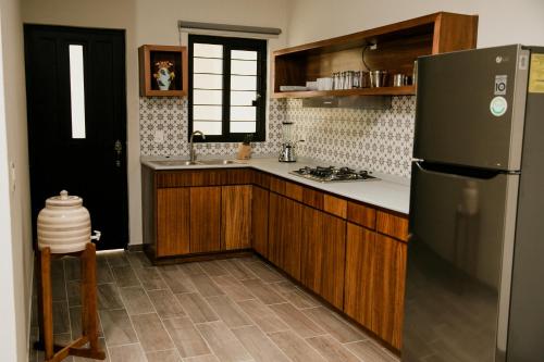 a kitchen with a black refrigerator and wooden cabinets at casa VOLCAN x Santiago de tequila in Tequila