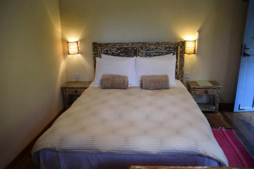 a bedroom with a large bed with two pillows at Sítio Flor das Águas in Lumiar