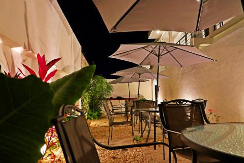 a group of tables and chairs with umbrellas at Margarett Hotel in Valladolid