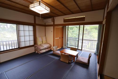 箱根町にあるOnsen & Garden -Asante Inn-のリビングルーム(テーブル、椅子、窓付)