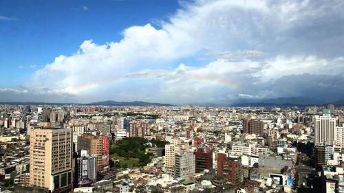 a city with a rainbow in the sky at Le Midi Hotel Jungli in Zhongli