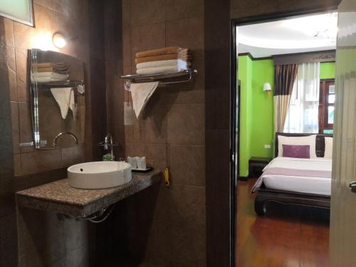 a bathroom with a sink and a bed in a room at Seashell Resort Koh Tao-SHA Plus in Ko Tao