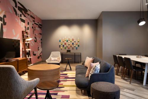 a living room with chairs and a tv and a table at Crowne Plaza Atlanta Perimeter at Ravinia by IHG in Atlanta