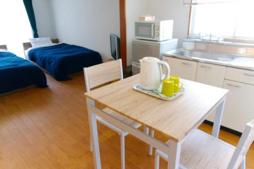 een kamer met een tafel en een keuken met een kamer met een keuken bij Apartment in Kochi - Vacation STAY 47741 in Kochi