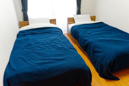 two beds in a room with blue sheets at Apartment in Kochi - Vacation STAY 47741 in Kochi
