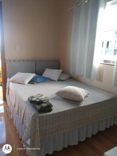 a bedroom with a bed with two pillows on it at Suítes da Rô - hospedaria familiar diária e temporada in Varginha