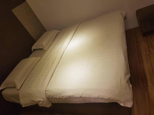 a large white bed in a small room at My Family Hotel in Port Dickson