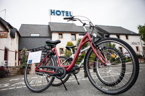 Hotel Le Branhoc - Brit Hotel Auray في أوري: دراجة حمراء متوقفة أمام الفندق