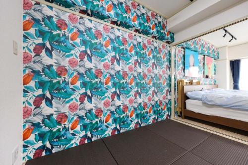 1 dormitorio con papel pintado de flores en la pared en Mezon Etowaaru, en Nagoya