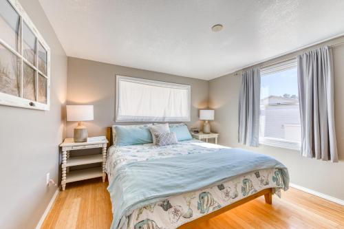 a bedroom with a bed and two windows at Vinovilla in Rockaway Beach