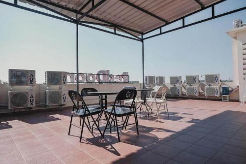 a patio with a table and chairs on a roof at RedDoorz Plus near Soekarno Hatta Airport Taman Mahkota in Tangerang