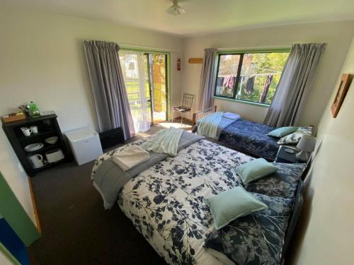 a bedroom with two beds and a window at White Elephant Accomodation in Motueka