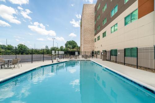 a swimming pool in front of a building at Holiday Inn Express & Suites Atlanta Airport NE - Hapeville, an IHG Hotel in Atlanta