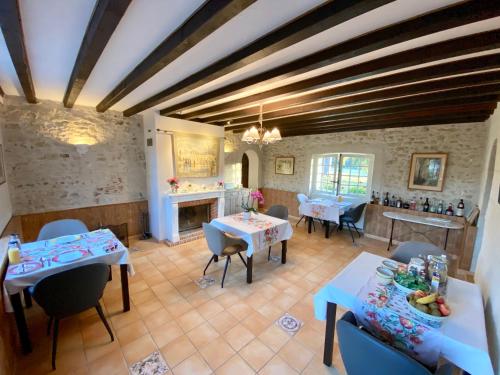 a living room with tables and chairs and a fireplace at Sans Souci Bed and Breakfast Luxe Heated Pool and Restaurant in Luzillé