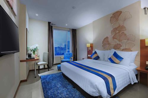una camera d'albergo con un letto grande e una grande finestra di Aston Inn Gideon Batam a Nagoya