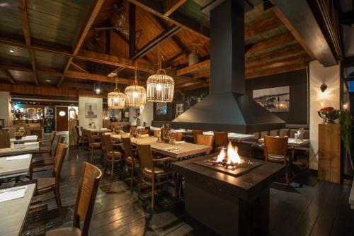 a restaurant with wooden ceilings and tables and chairs at Hotel & Restaurant - Auberge De Hilver in Diessen