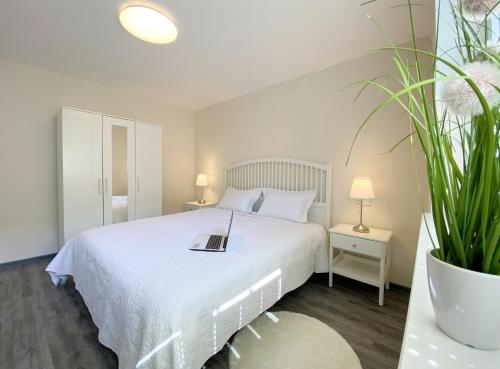 a bedroom with a white bed with a book on it at REGIOHOTEL Aparthotel Wernigerode in Wernigerode