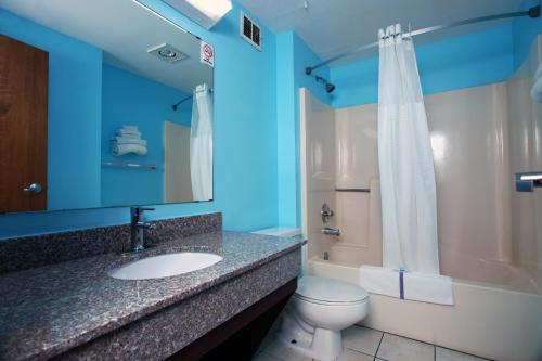 a bathroom with a sink and a toilet and a shower at Coratel Inn & Suites by Jasper Newton in Newton