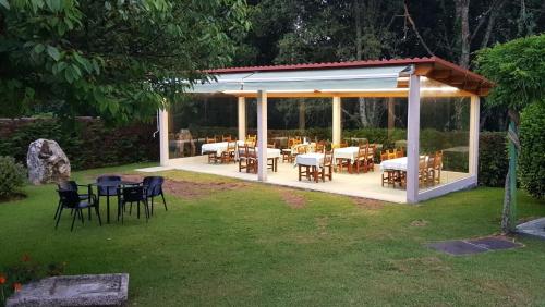 a gazebo with tables and chairs in a yard at El Retiro in Nigrán