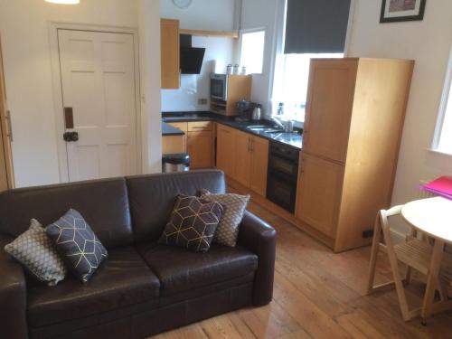 a living room with a couch and a kitchen at City Centre - The Old Committee Room-free parking in York