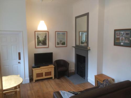 a living room with a fireplace and a television at City Centre - The Old Committee Room-free parking in York