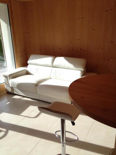 ein weißes Sofa in einem Zimmer mit einem Tisch in der Unterkunft 2-Zimmer Ferienwohnung,Parterre,Sitzplatz,Garage in Adelboden